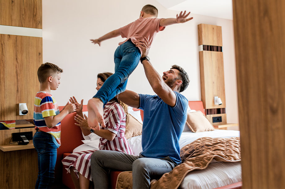 slider-family-playing A family playing happily in bedroom setting